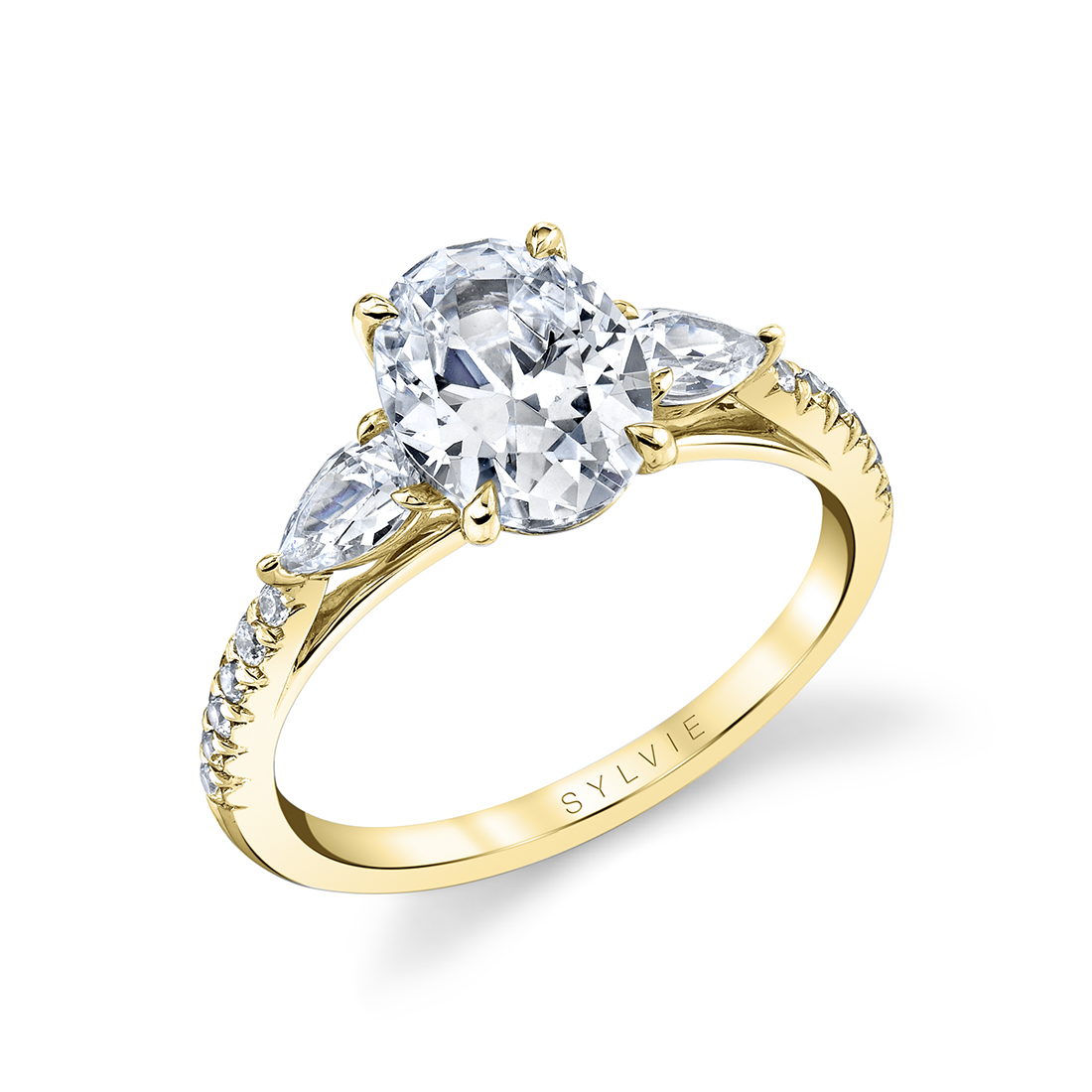 oval engagement ring with pear side stones in yellow gold