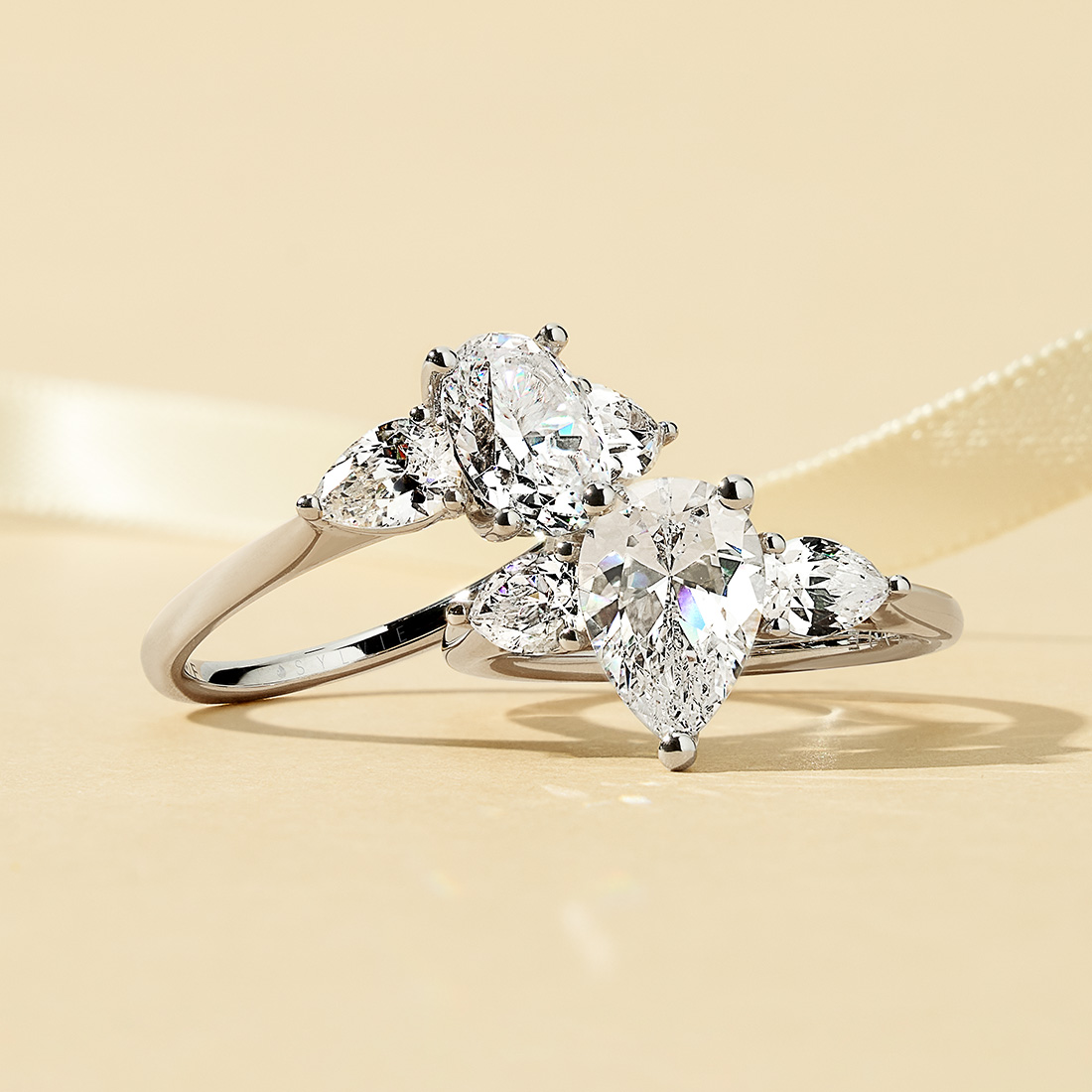 pear shaped and oval cut three stone engagement rings in white gold